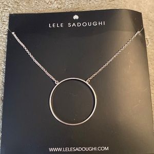 Silver circle necklace with a lobster claw clasp for strength during wear.